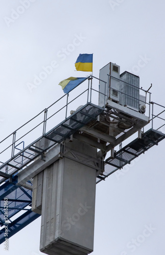Ukraine flags on top of tower construction crane