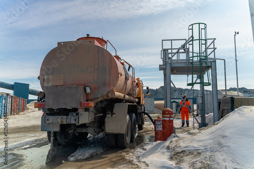 Refueling a truck carrying fuel at a gold mining site.