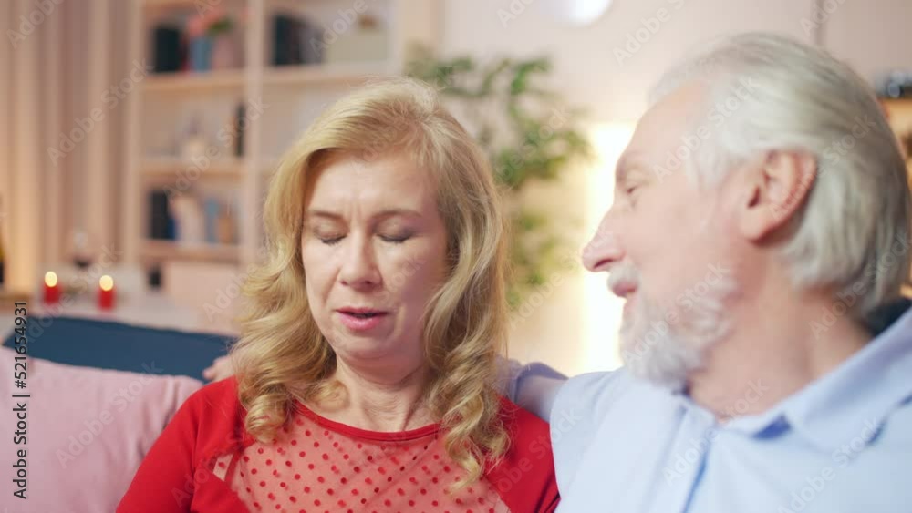 Happy middle-aged couple talking and cuddling at home, spending time together Happy middle-aged couple talking and cuddling at home, spending time together