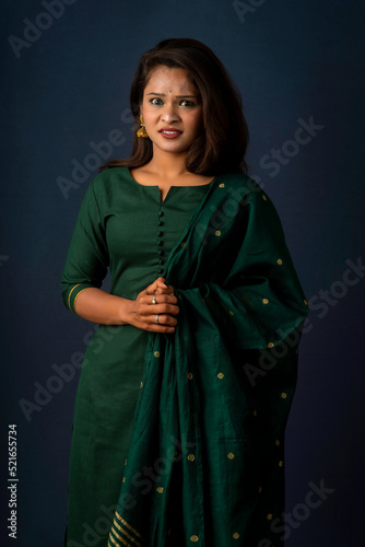 Scared beautiful female, looks nervously, afraid of something, poses against a gray background. Fear, panic, stress, and anxiety