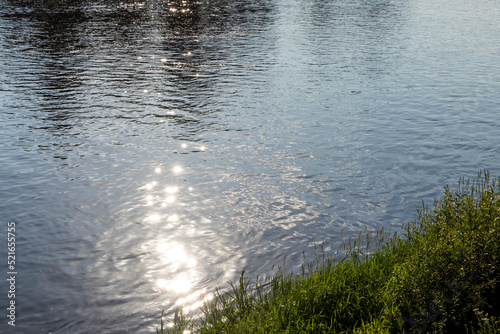 Sun glare in the water of the river with waves