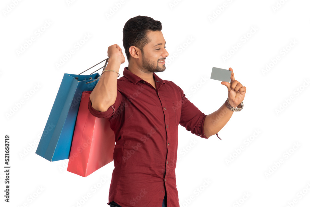young man holding and posing with shopping bags with credit or debit card on a white background young man holding and posing with shopping bags with credit or debit card on a white background