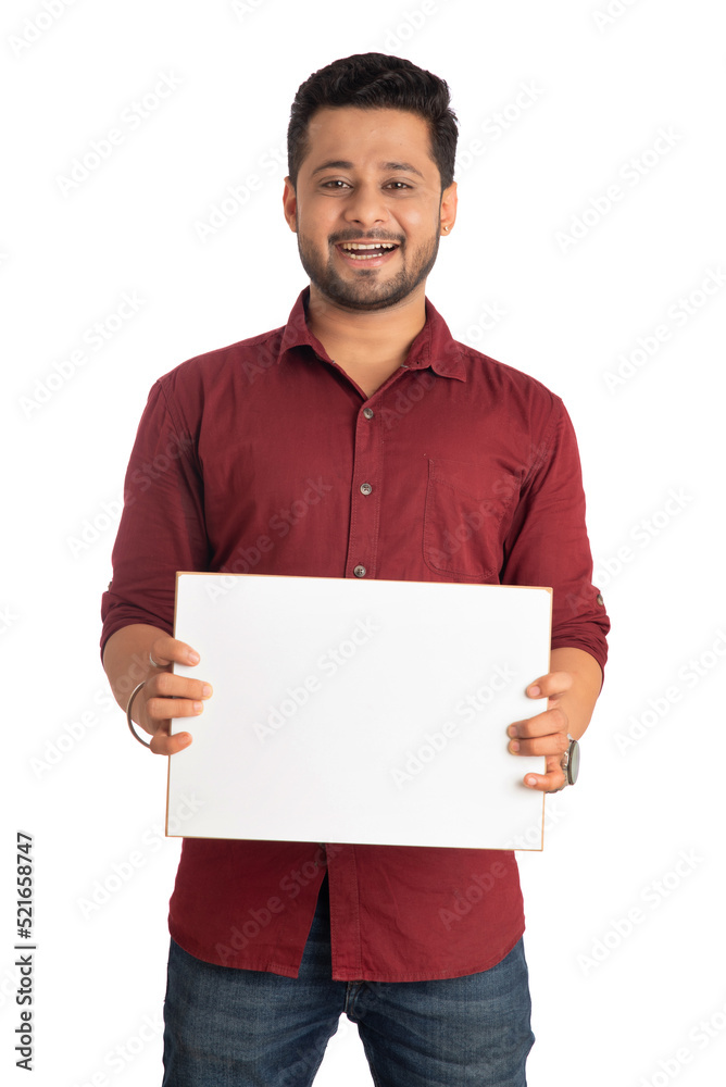 A happy young man holding and displaying a signboard or placard in his hands on a white background. A happy young man holding and displaying a signboard or placard in his hands on a white background.