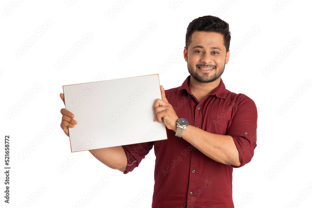 A happy young man holding and displaying a signboard or placard in his hands on a white background. A happy young man holding and displaying a signboard or placard in his hands on a white background.