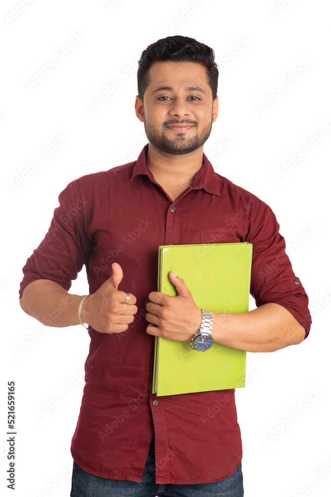 Young happy man holding and posing with the book on white background. Young happy man holding and posing with the book on white background.