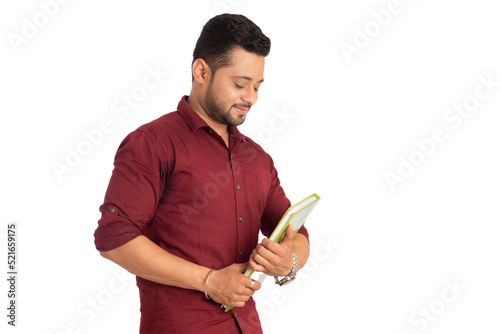 Fotografía Young happy man holding and posing with the book on white background