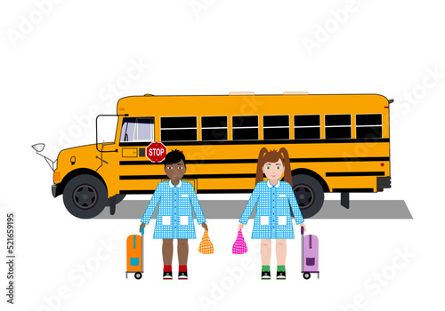 La vuelta al cole. Pareja de escolares con bata escolar, bolsa de almuerzo y mochila de ruedas delante de un autobús o bus escolar amarillo americano
