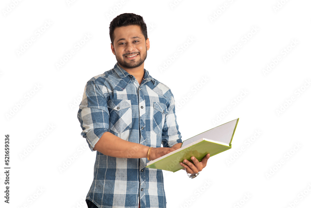 Young happy man holding and posing with the book on white background.