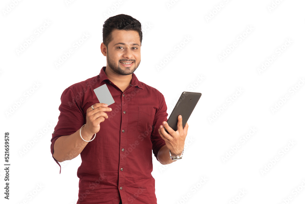 Young smiling man presenting a credit card while using a smartphone or buying online on mobile with a credit card Young smiling man presenting a credit card while using a smartphone or buying online on mobile with a credit card