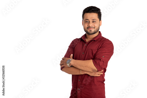 Portrait of a happy young man posing with arms crossed or hands folded on a white background