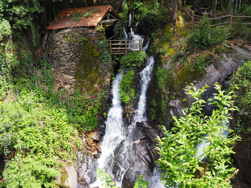 cascada de aguas bravas bajando sobre las rocas del río tambre, a la izquierda un antiguo telar con un mirador de madera, mezónzo, la coruña, europa