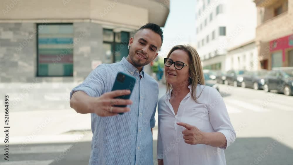 Man and woman mother and daugther make selfie by smartphone at street Man and woman mother and daugther make selfie by smartphone at street