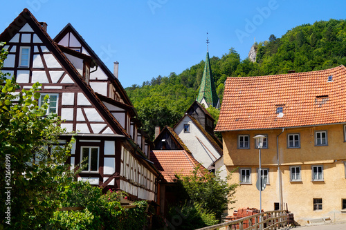 Wallpaper Mural old timber-framed houses on the River Blau (or Blue River) near the turquois pond called Blautopf (Blue Pot) and beautiful old Blaubeuren Abbey in the background (Blaubeuren, Germany)	 Torontodigital.ca