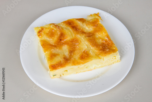 Turkish style meat stuffed filo dough borek served kol boregi. Cheese and minced pie are sliced on a marble background. Turkish name: Kol Boregi, kiymali, peynirli su boregi.