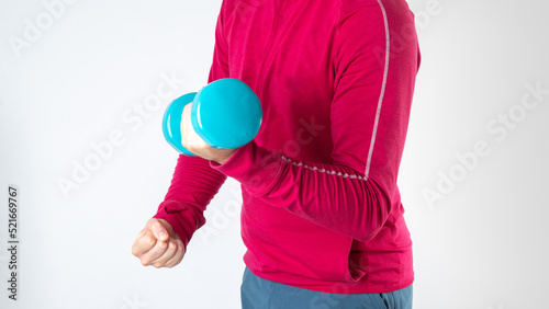A man swings his biceps with a dumbbell in his hand on a white background, sports training © Ekaterina