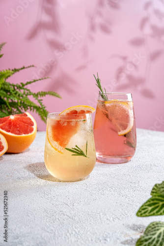 Summer refreshing sparcling cocktails with grapefruit. Lemonade garnished with fresh rosemary. Summer beverage with sparkling water and grapefruit slices.