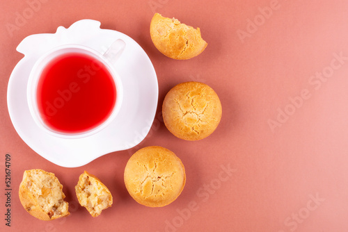 Berry tea in a white cup on a saucer and rice cupcakes on a pink-peach background. Space for text. Rice flour muffins. The concept of proper nutrition, a gluten-free diet. Breakfast.