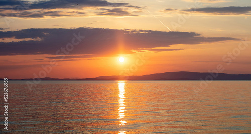 Sunset over Aegean Sea. Greece. Golden reflection on rippled ocean water. Dark land and colorful sky © Rawf8