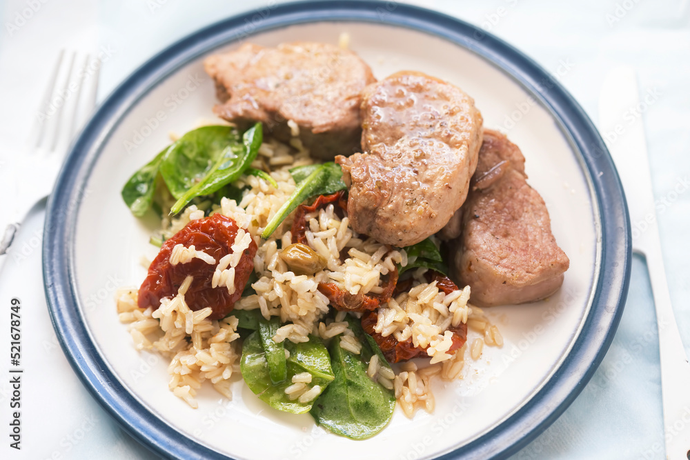 Pork loin with rice, spinach and sun dried tomatoes