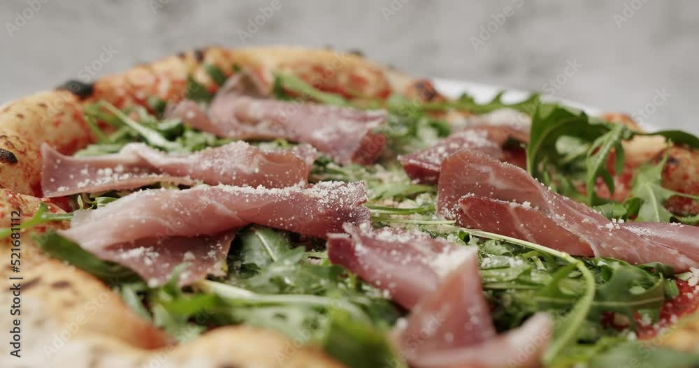 Close Up Pizza with prosciutto parma ham and Parmesan, arugula salad rocket with ingredients. Italian cuisine. Prosciutto pizza with strachatella cheese, tomatoes, arugula leaves. Close Up Pizza with prosciutto parma ham and Parmesan, arugula salad rocket with ingredients. Italian cuisine. Prosciutto pizza with strachatella cheese, tomatoes, arugula leaves.