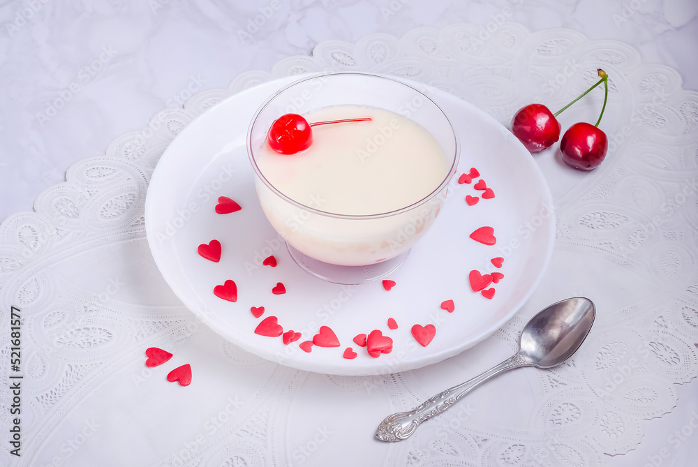 White vanilla dessert sprinkled with hearts on gray marble background for Valentine's Day White vanilla dessert sprinkled with hearts on gray marble background for Valentine's Day