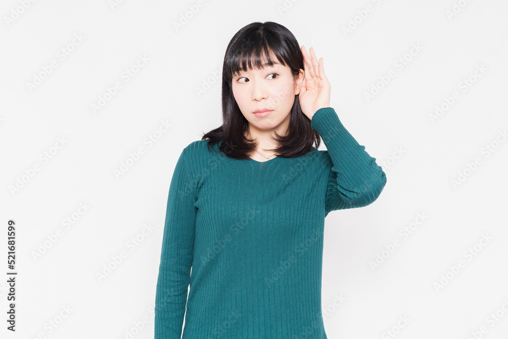 白背景の前で、聞き耳を立てている女性 白背景の前で、聞き耳を立てている女性