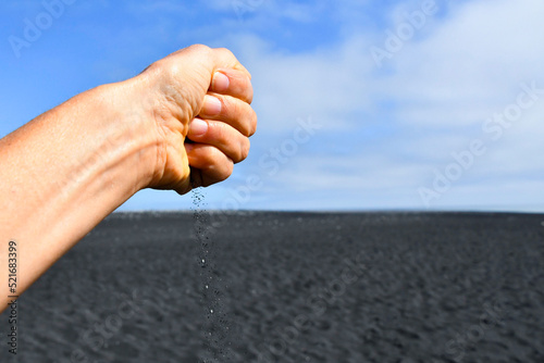 Hand dropping black sand