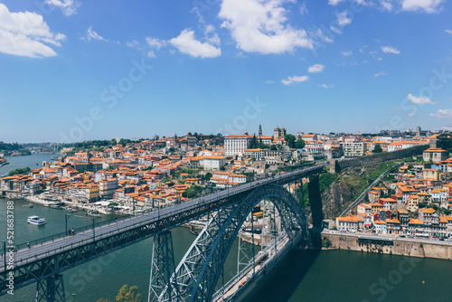 View of Iron famous bridge and Duoro bay in Oporto city from top with boats navigating 