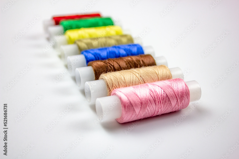 Sewing threads.Colored threads on a white background. Spools of thread for sewing. Thread selection. Sewing threads.Colored threads on a white background. Spools of thread for sewing. Thread selection.