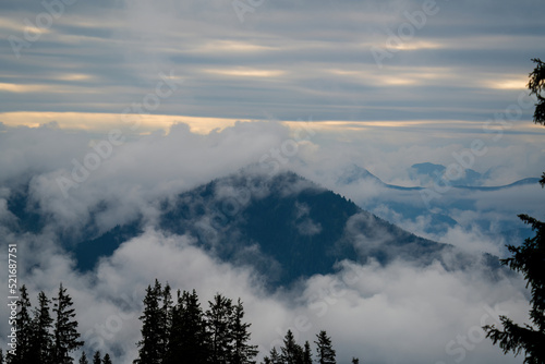 mystical foggy landscape in the mountains with view of the alps at a summer morning