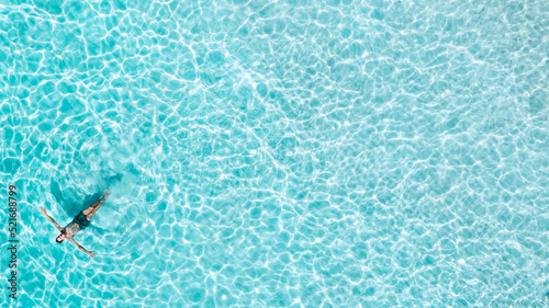 Aerial view of a man swimming at the sea with copy space