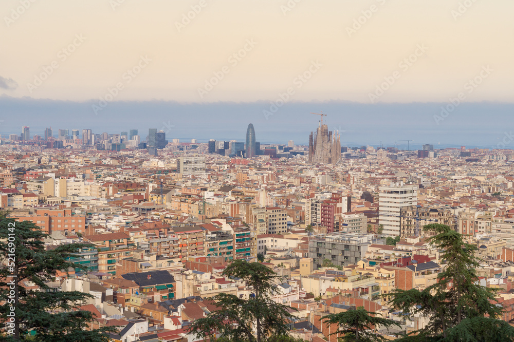 Views of the city of Barcelona at sunset with the emblematic Sagrada Familia and the Agbar Tower in the background.