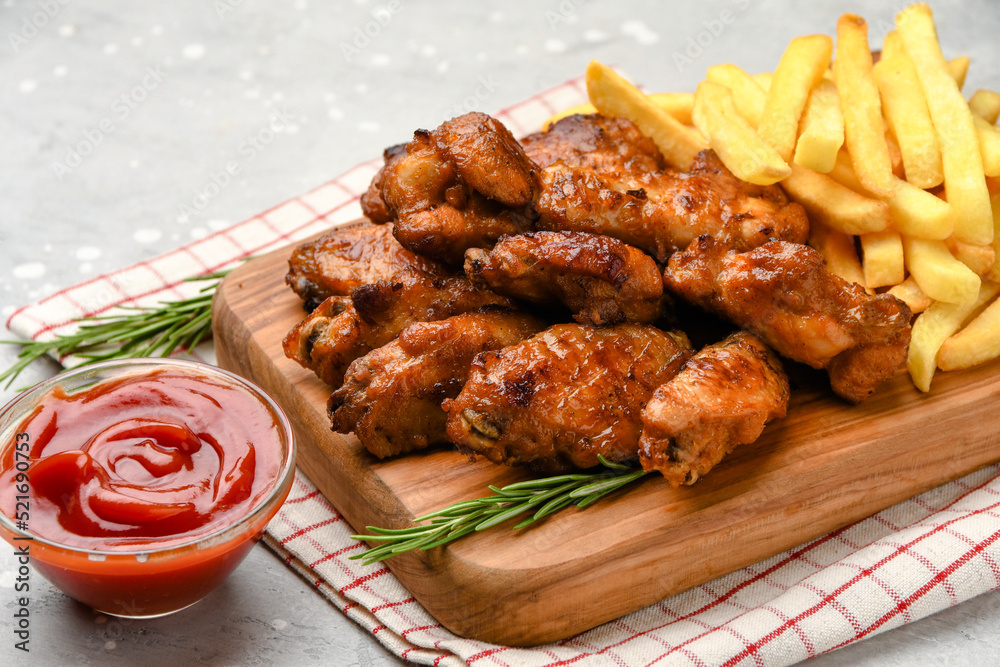 Spicy chicken wings with potatoes fries and ketchup. 