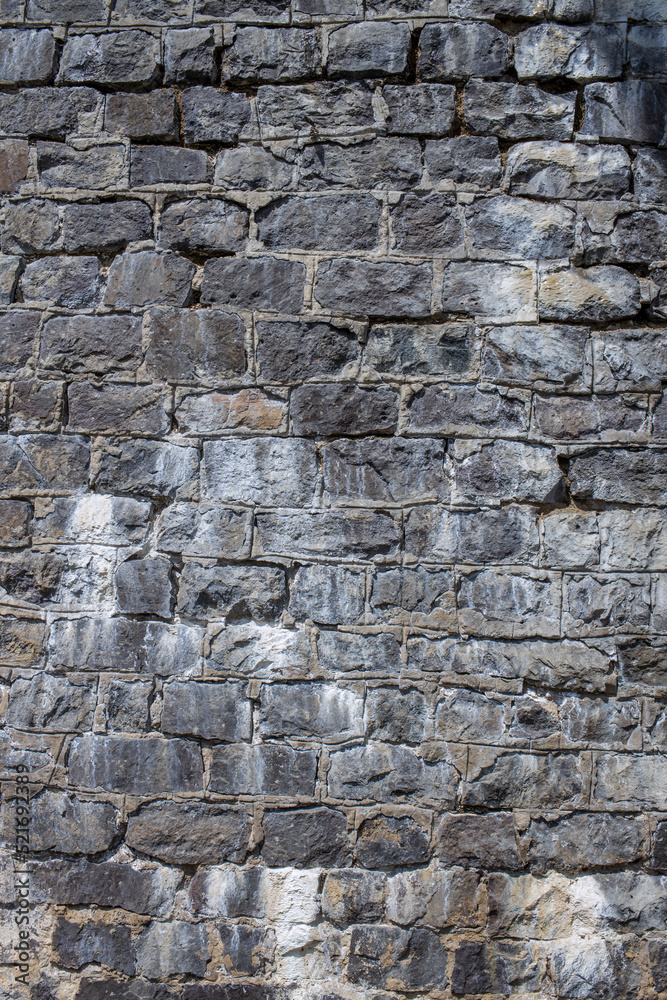The texture of the stone wall in gray. Rough grunge texture of natural origin. The texture of the stone wall in gray. Rough grunge texture of natural origin.
