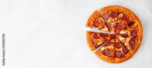 Fotografia Classic pepperoni pizza with cut slices