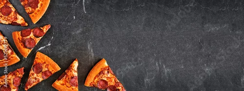 Panel kuchenny z motywem Pepperoni pizza slice corner border. Top view over a dark slate banner background. Copy space.