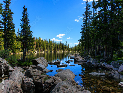 Large boulders mark the short of an alpine lake deep in the Rocky Mountains of Colorado