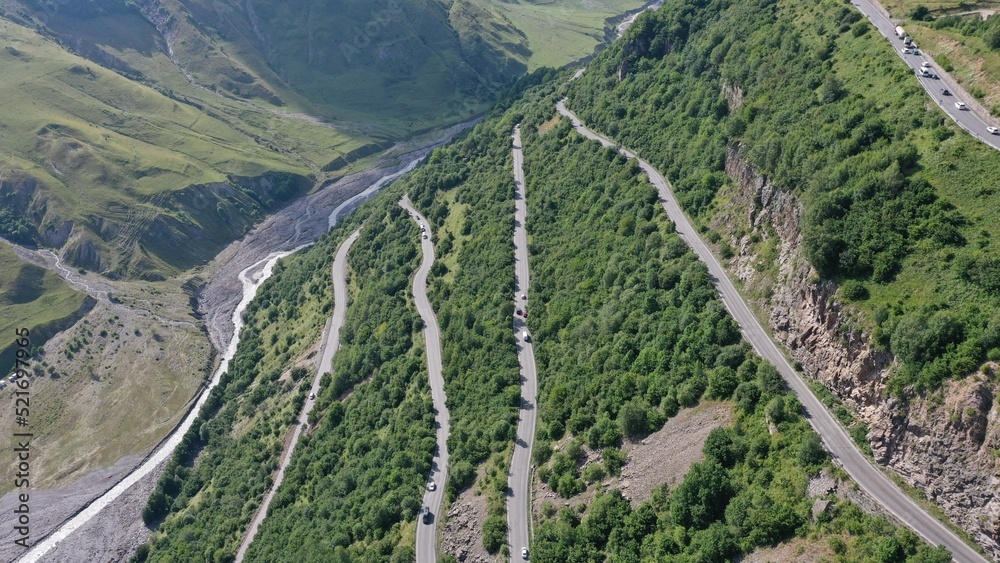 Aerial view of Georgian Military Road with sharp turns and heavy traffic. Kazbegi, country of Georgia