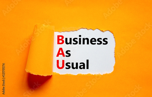 BAU business as usual symbol. Concept words BAU business as usual on white paper on a beautiful orange background. Business and BAU business as usual concept. Copy space. photo