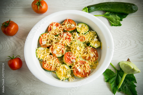 raw zucchini and tomatoes sliced with cheese, prepared for baking