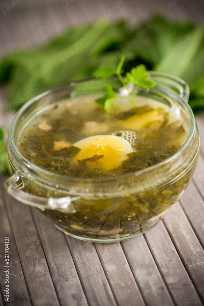 Spring soup from fresh sorrel with boiled eggs in a plate