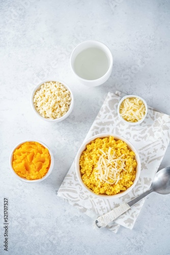 Millet porridge with pumpkin puree and cheese in a bowl