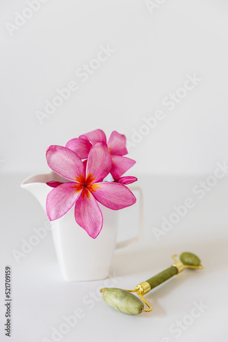 Plumberia rumba in a coffe cup, eucalyptus branch in a vase and cup of coffee on a white table against a wall with two frames. Ready layout. Vertical frame. Space for text