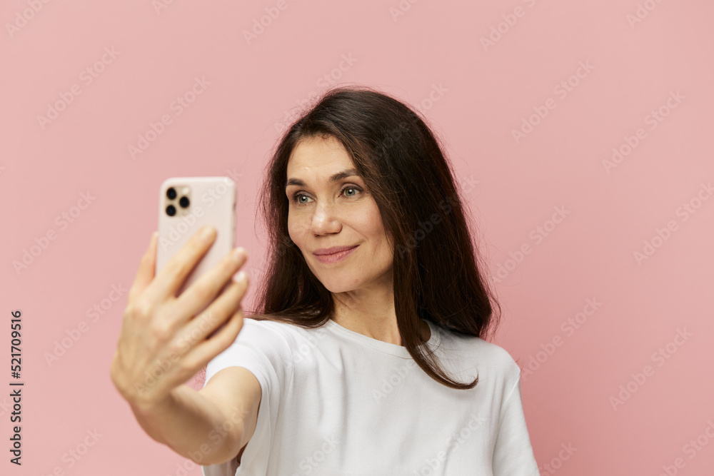portrait of a beautiful emotional woman with a fashionable phone in her hands takes a selfie with her hand outstretched forward portrait of a beautiful emotional woman with a fashionable phone in her hands takes a selfie with her hand outstretched forward