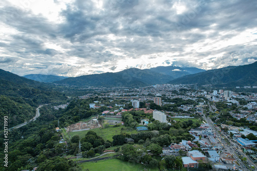 Colombia - Ibague, vista de dron con una montaña, la ciudad de ibague, una carretera en la mitad y un maravilloso cielo y nubes.