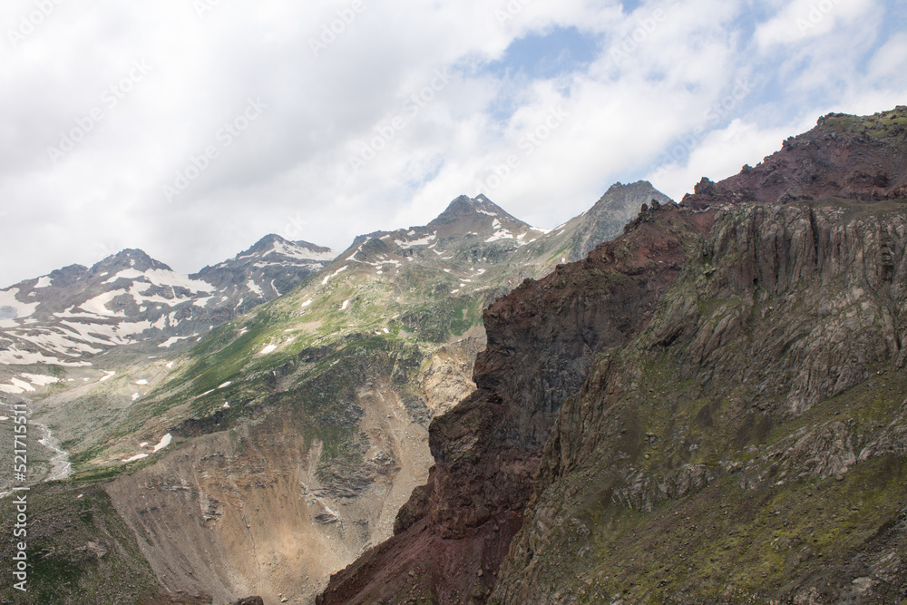 Panoramic dramatic top view in the Elbrus region of Russia - peaks of high mountains with glaciers and snow on a foggy cloudy day and a space for copying soft focus Panoramic dramatic top view in the Elbrus region of Russia - peaks of high mountains with glaciers and snow on a foggy cloudy day and a space for copying soft focus
