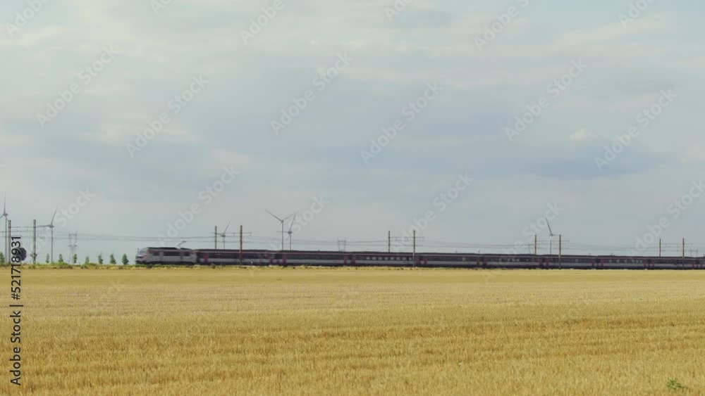 Passing highspeed train in rural summer country landscape.  Cross country rail service. High-speed train movement. Modern high speed train. The high-speed intercity train moves on the railroad. 