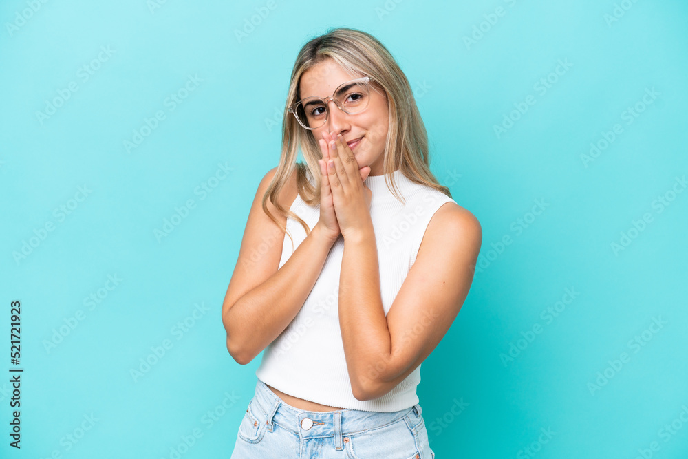 Young caucasian woman isolated on blue background keeps palm together. Person asks for something Young caucasian woman isolated on blue background keeps palm together. Person asks for something
