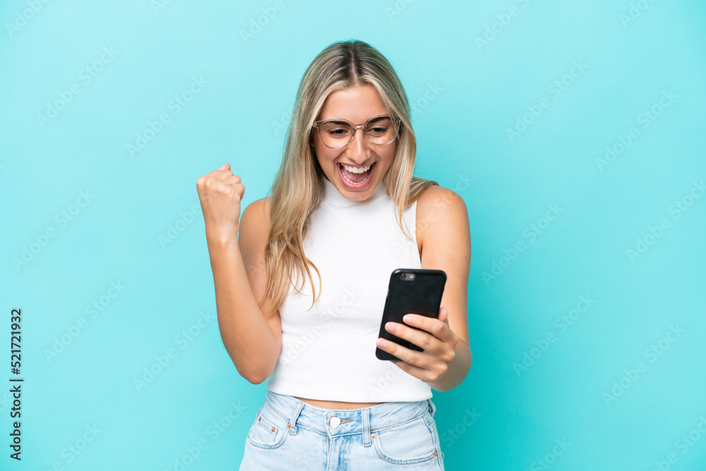 Naklejka premium Young caucasian woman isolated on blue background surprised and sending a message