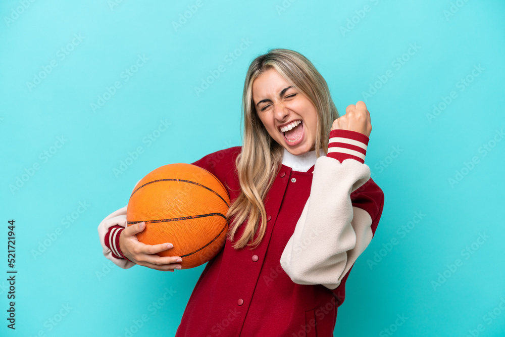 Young caucasian basketball player woman isolated on blue background celebrating a victory Young caucasian basketball player woman isolated on blue background celebrating a victory